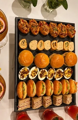 Plateau traiteur Edmond garni de mini-burgers, wraps roulés, œufs mimosa et sandwichs club